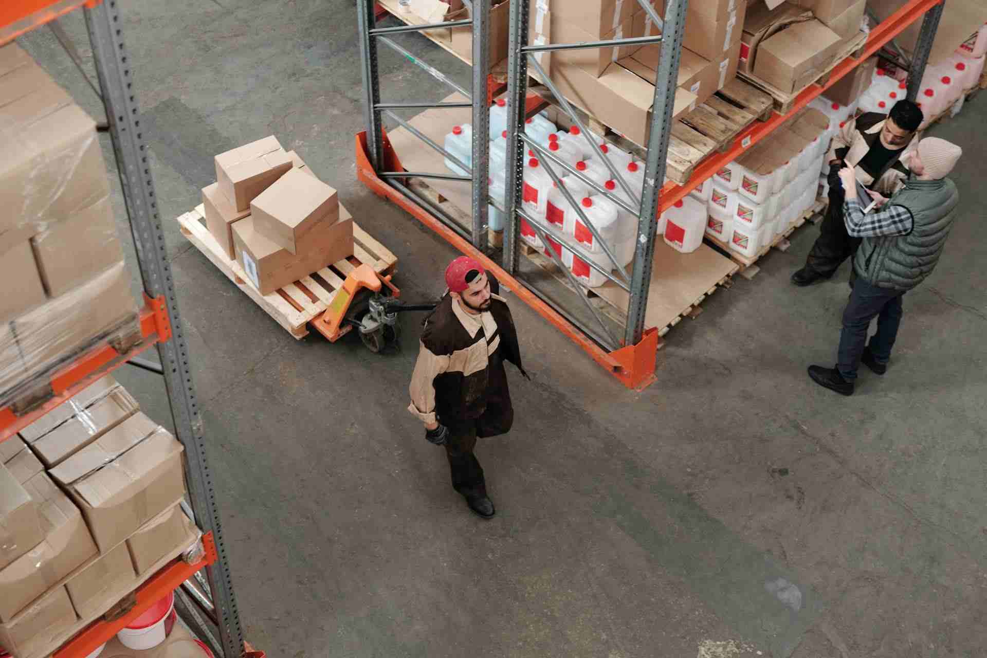 man-pulling-a-cart-with-boxes-on-top-of-it-in-a-warehouse