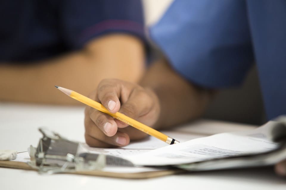 person-holding-a-pencil-over-paperwork