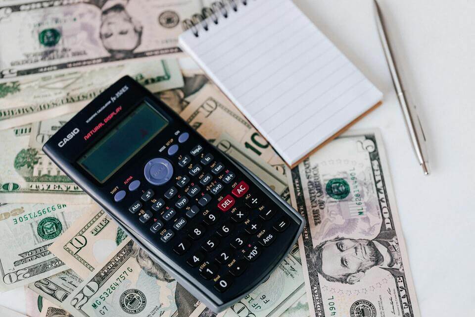 calculator-and-notepad-on-top-of-cash