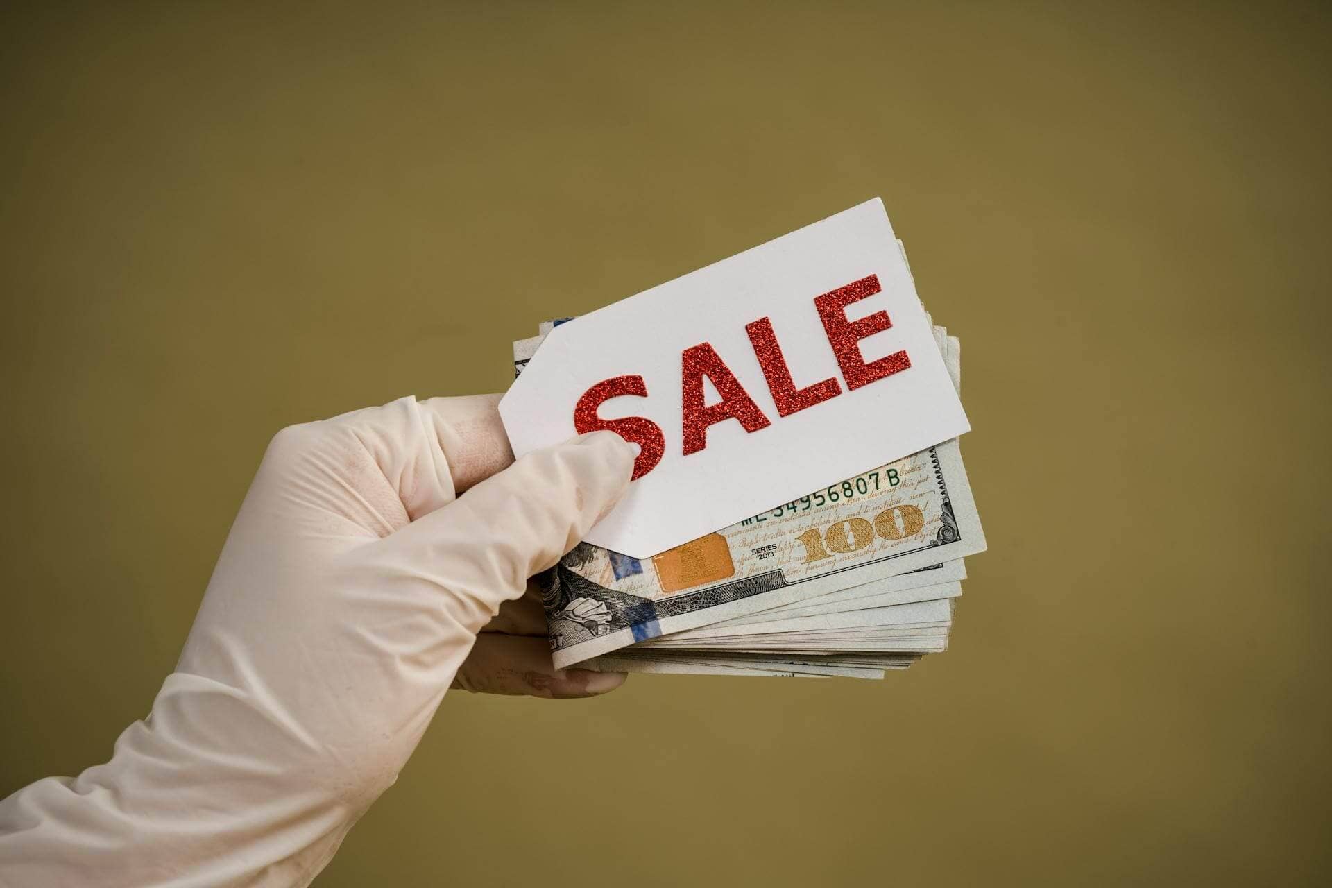 person-holding-a-tag-saying-sale-and-money