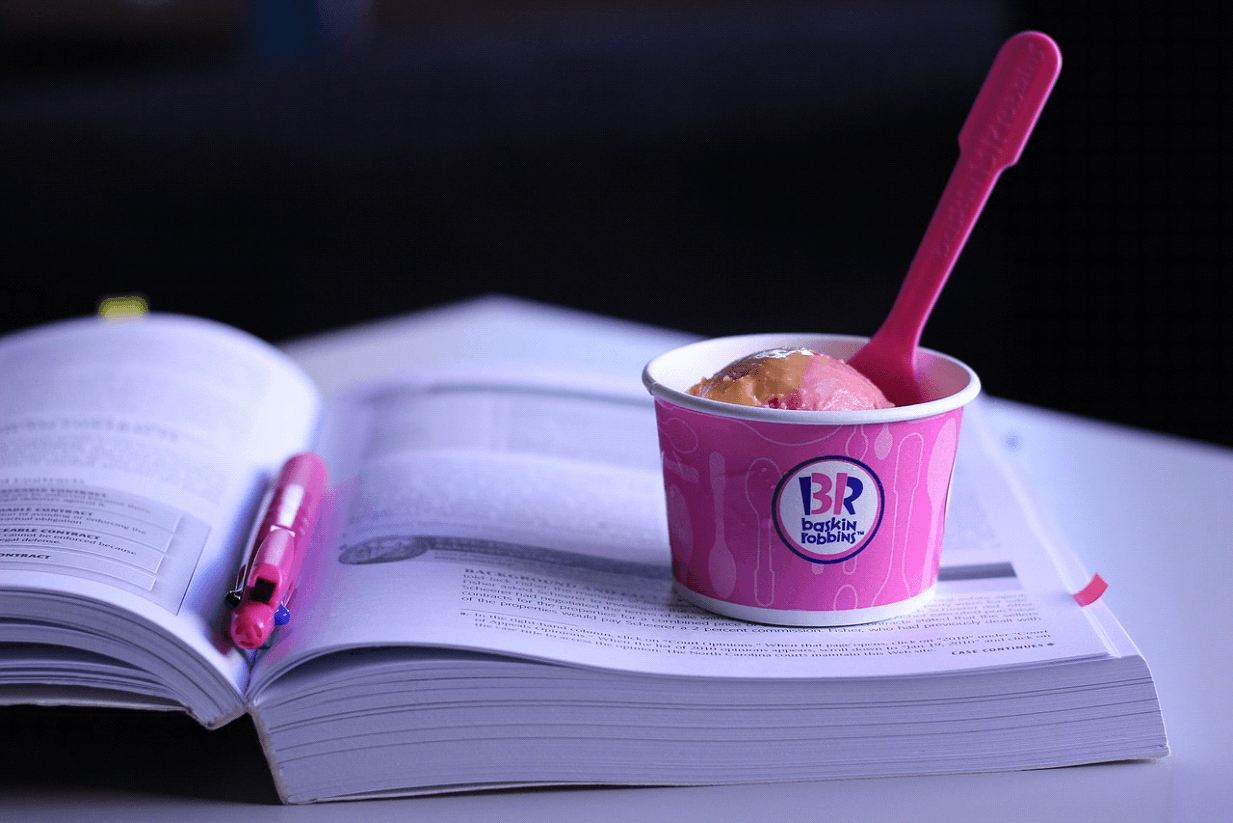 a cup of Baskin Robbins ice cream on top of a book