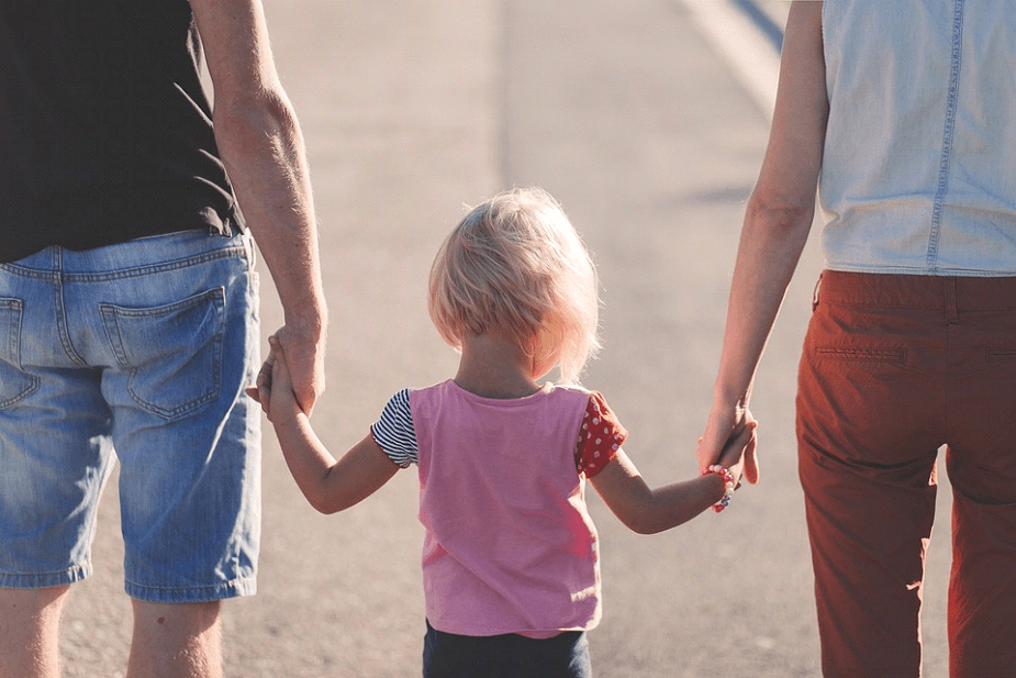 child holding hand of parents