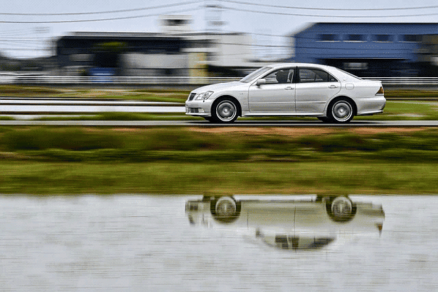 car-driving-past-a-river