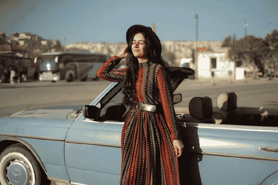 model-standing-in-front-of-a-car