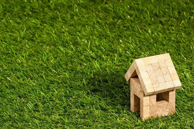 house-made-of-wooden-blocks-in-a-field-of-grass