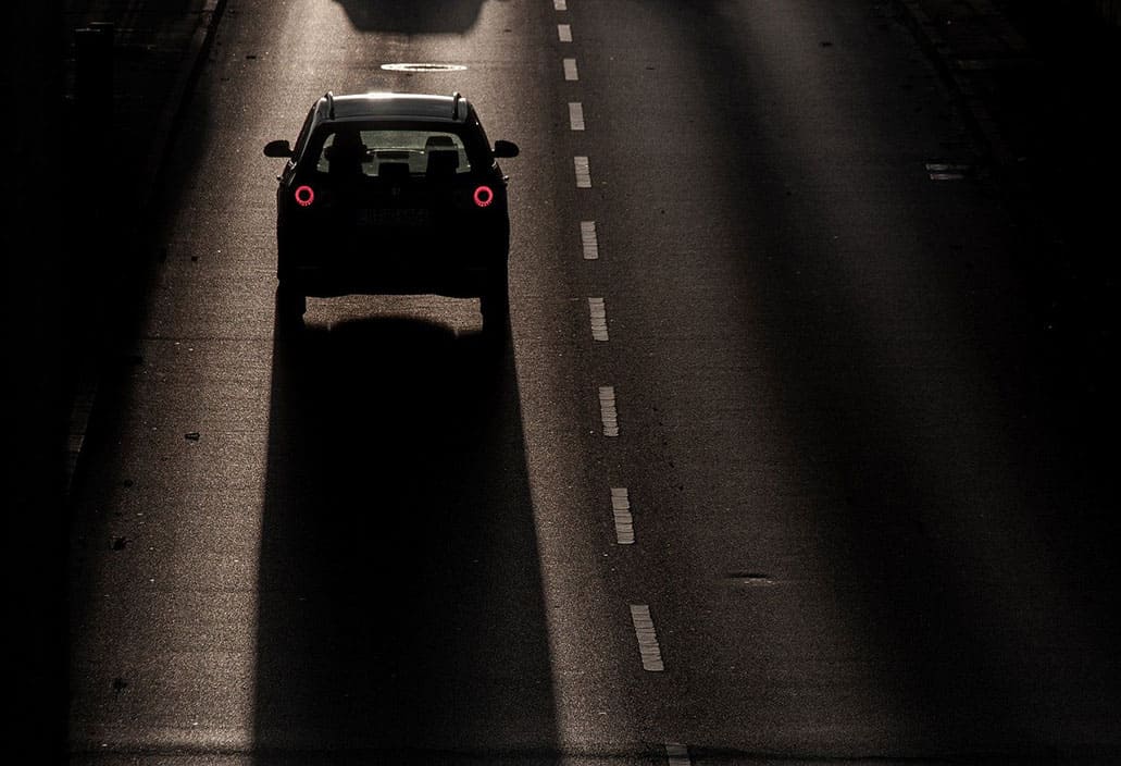 car-driving-down-a-road-at-night